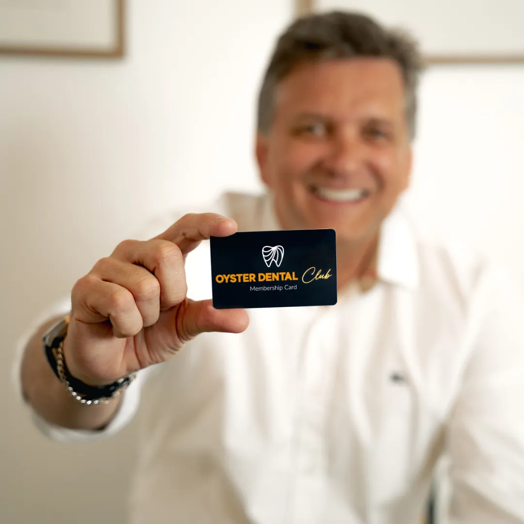Patient holding the Oyster Dental Club card